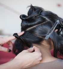 Step 2: Take the bottom section, wrap hair around finger, and twist to form a figure-eight. 18_26_style3_step2