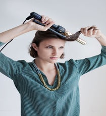 Separate this hair into four to six smaller pieces, depending on the thickness and length of your hair. Using a one-inch curling iron, wrap each section loosely around the curling iron, directing the hair away from your face.
Joie Marlo D Top, Noise Girl Lyle Necklace quick-beauty-2