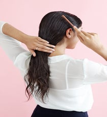 Comb back the sides around the ears; hold it parallel to the part, then comb down to the temple and sweep toward the back of the hair around the ear to sculpt the hair into an artistic shape. LowBun_020_R