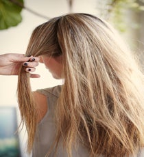 Step 1: Part hair in the center. Take a three-inch section from the part to the ear. style4_step1