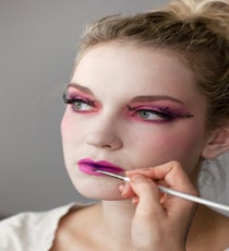 Using a brush, apply a dark purple eyeshadow (the same one you used on your eyes) to the very center of the mouth, closest to the teeth. Evans suggests concentrating the color on the middle and then blending it outwards on the lip, so it gradually fades out. 15_HalloweenLook1_091512_548