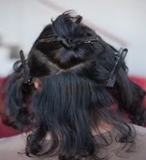 Step 1: Spritz hair with texturizing spray, then add a dab of anti-frizz cream. Separate hair into six sections and clip: One diamond-shaped section in the middle and sections at the bottom, bottom left, top left, bottom right, and top right. 17_25_style3_step1